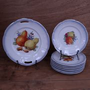 Set of 7 dessert plates and a cake stand with fruit patterns.