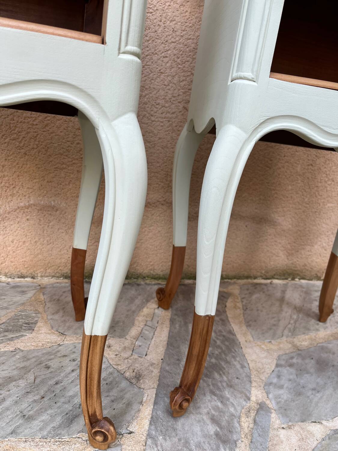 Renovated bedside tables in laurel green and light wood.