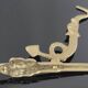Vintage brass coat hook with marine creature motif and medallion.