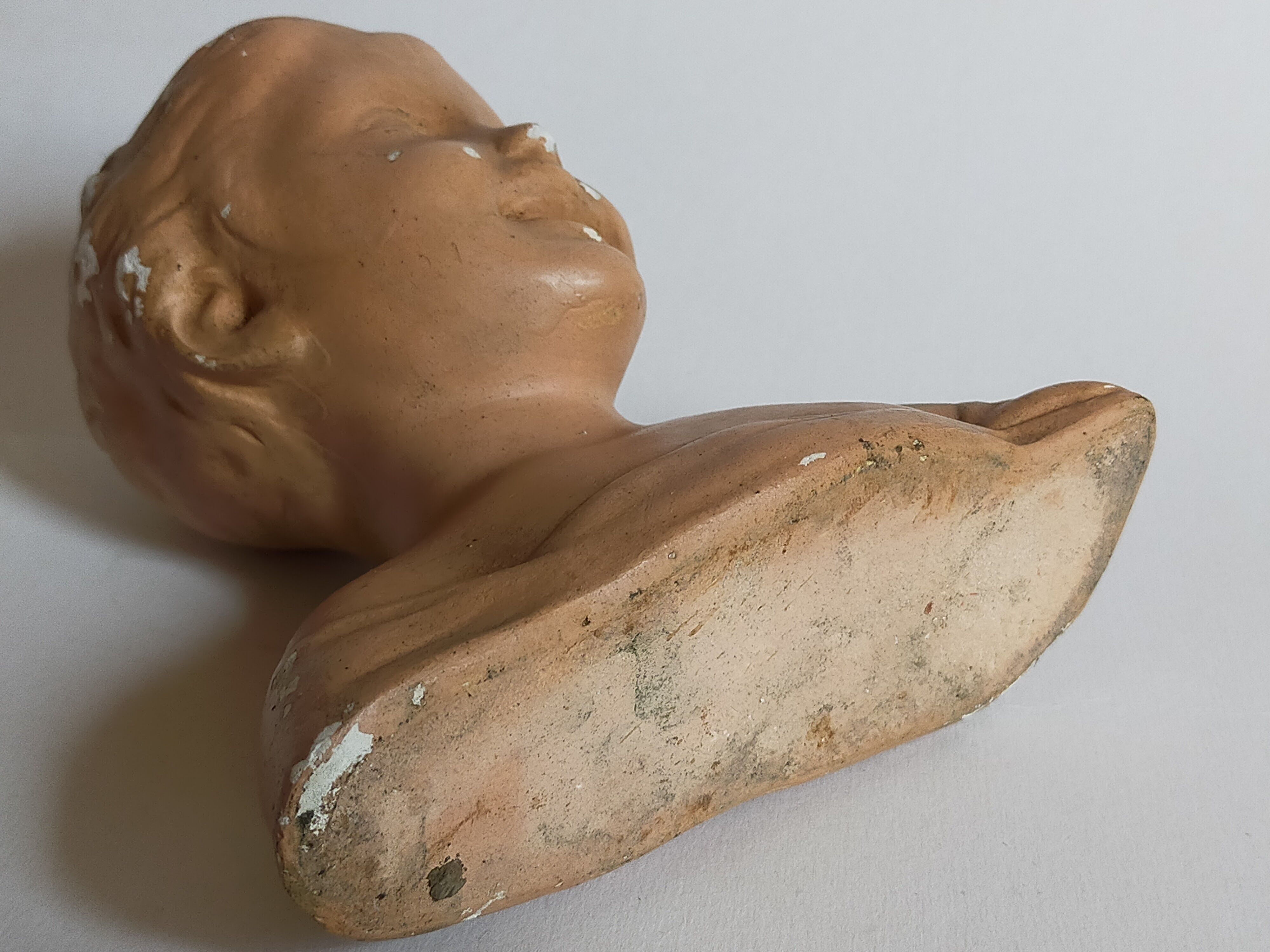 Bust of a small child in ancient plaster
