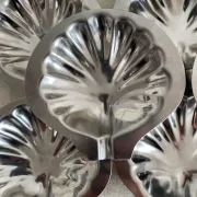 Set of 12 stainless steel scallop shells, 1970s-80s.