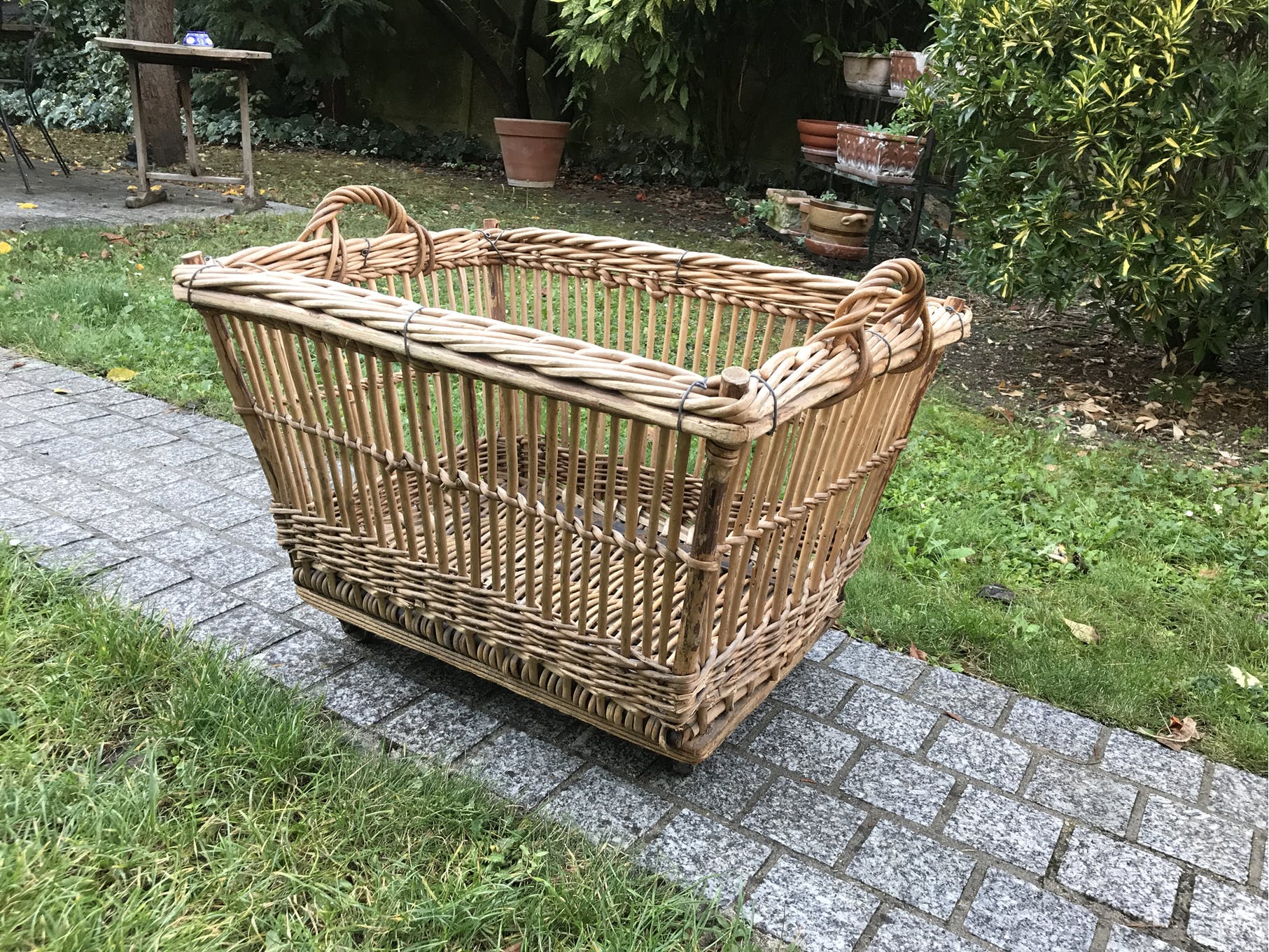 Rattan laundry basket on vintage wheels
