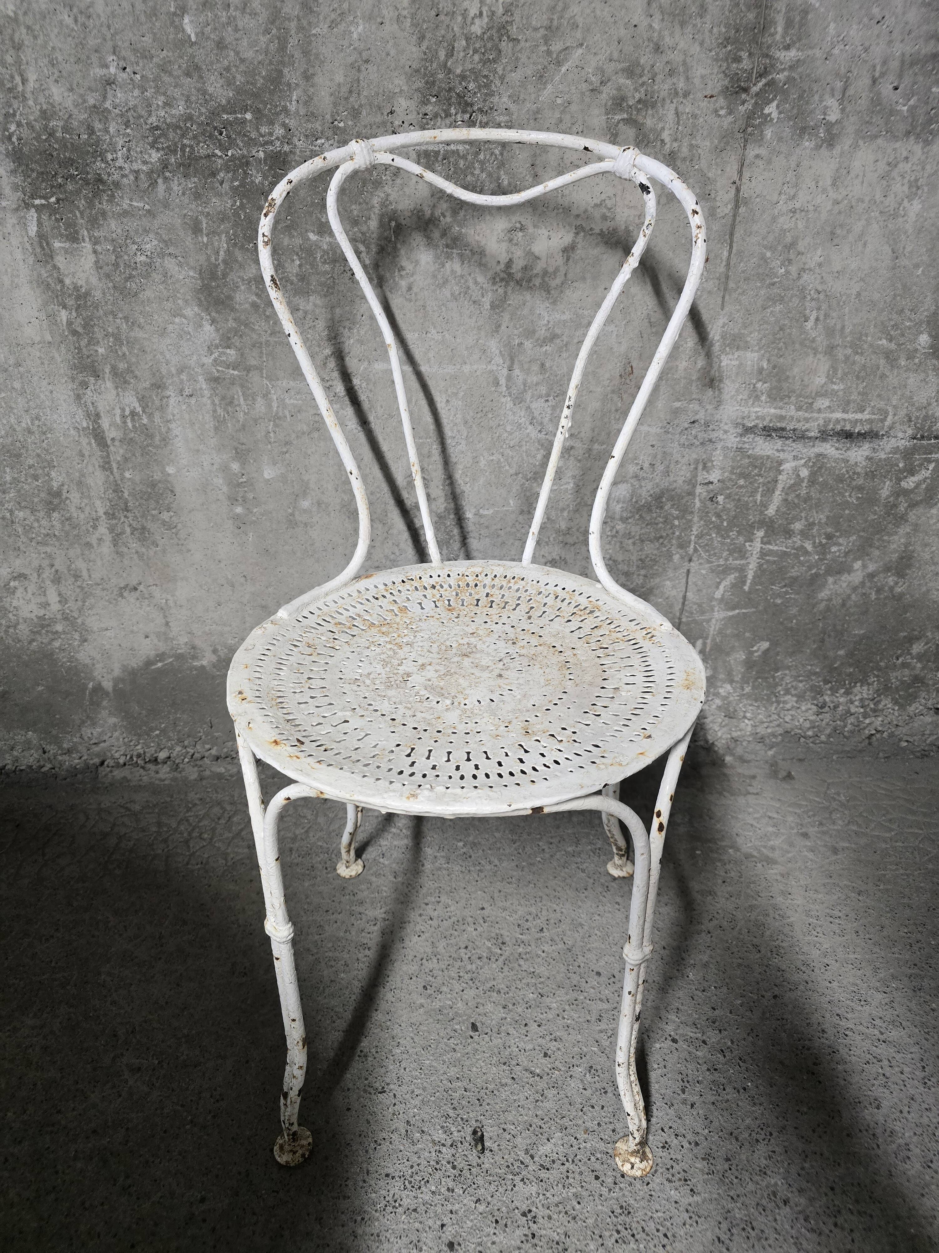 Antique painted wrought iron garden furniture, round table and four chairs.