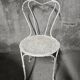 Antique painted wrought iron garden furniture, round table and four chairs.