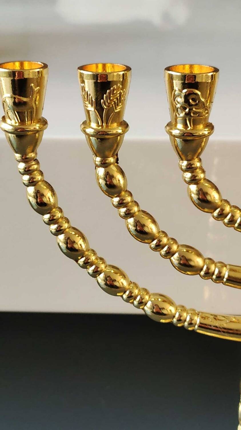 Menorah/Jewish/Hebrew candlestick with 7 arms of light. Engraved with the symbols of the 12 tribes of Israel/Holyland inscription. In gold metal. Size 20 x 16 cm