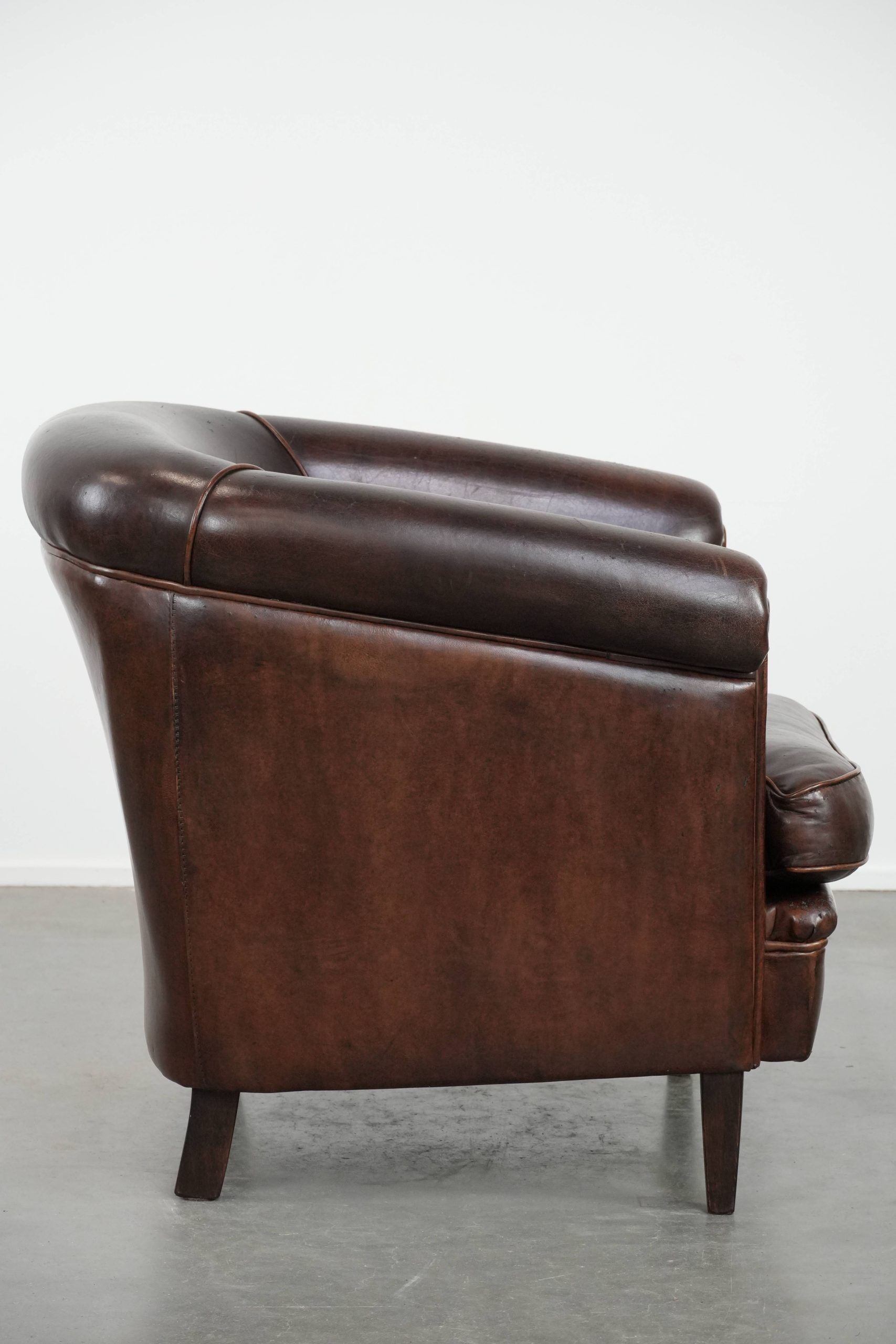 Dark brown vintage club armchair in English style made of sheepskin leather