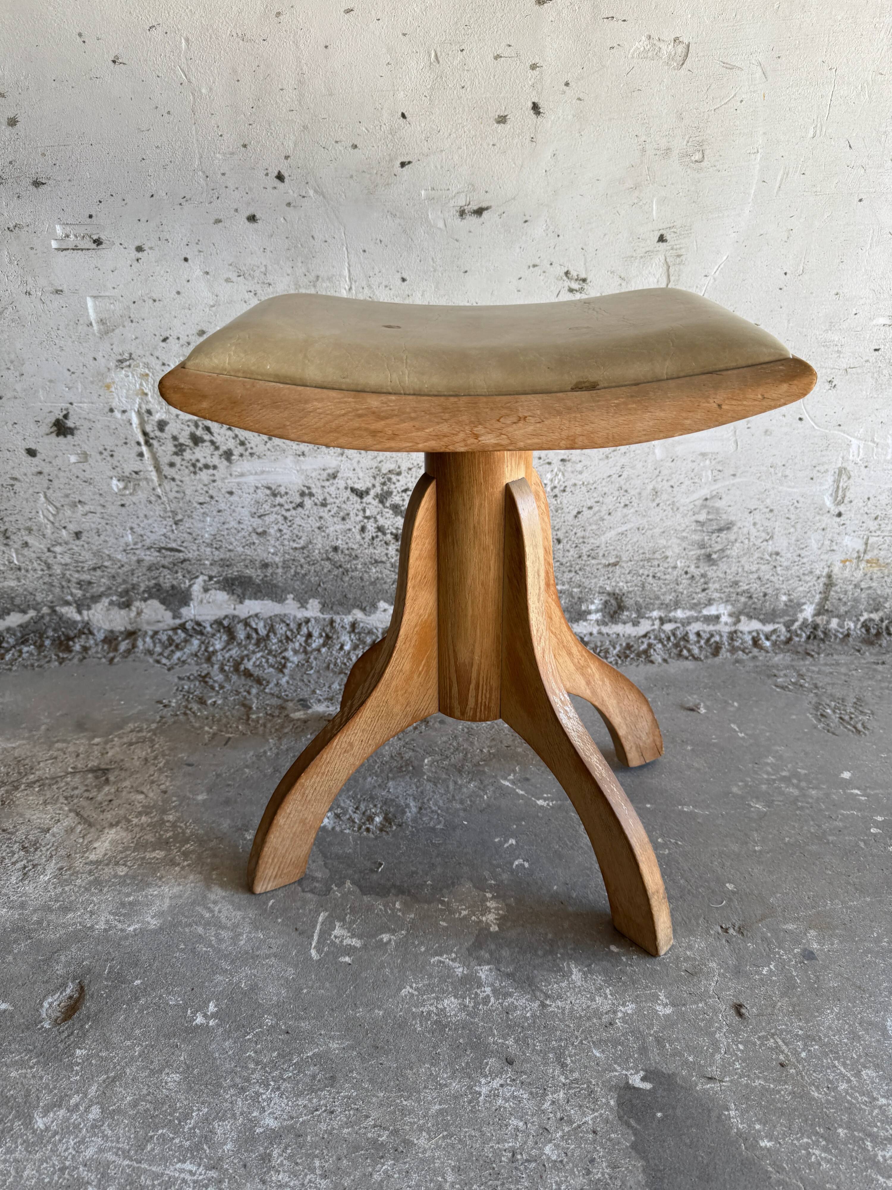 Vintage natural wood stool with light yellow faux leather seat and crossed splayed base