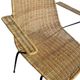 Vintage wicker chair with black steel frame and armrests