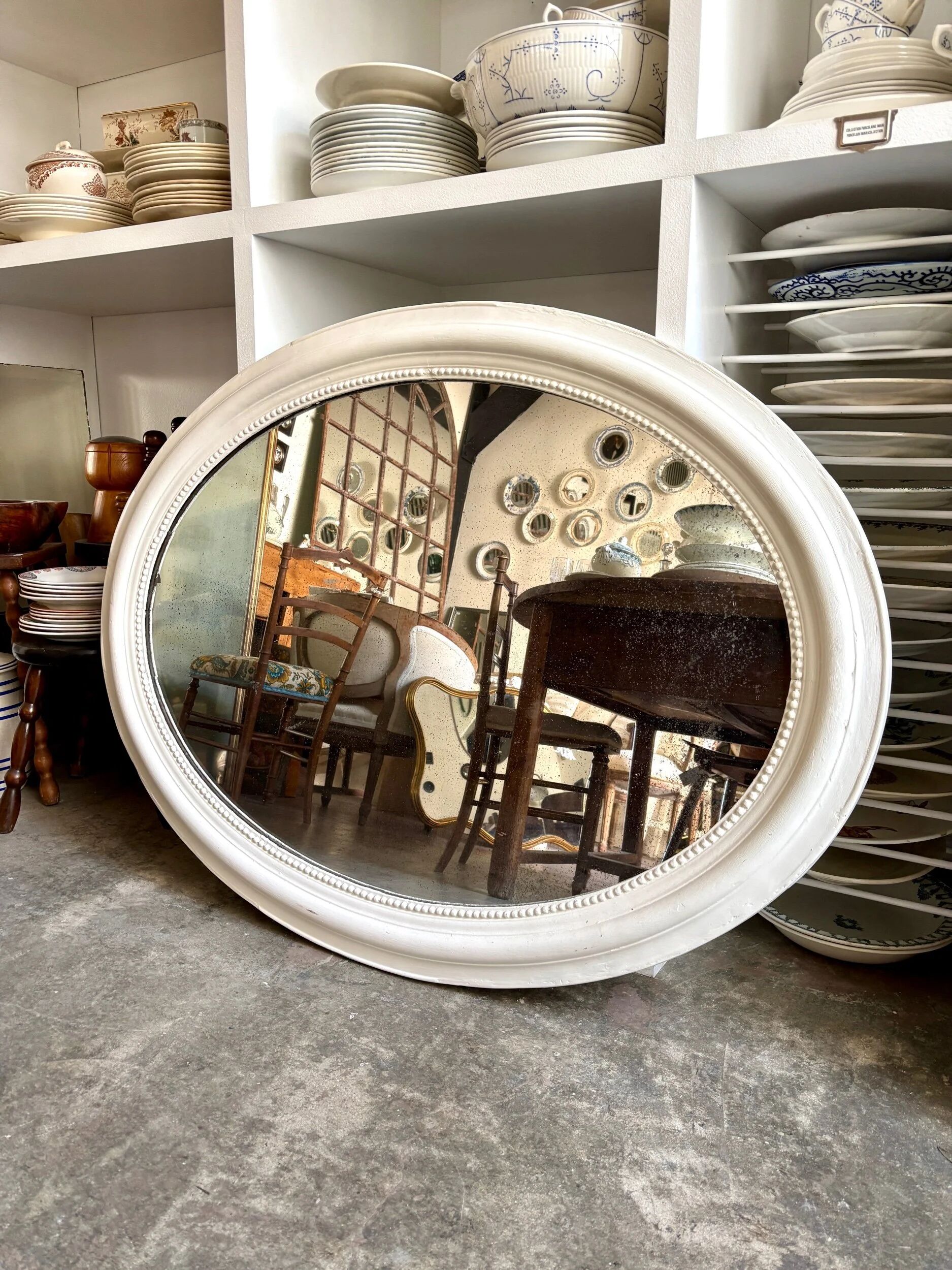 Oval mirror in pearl-coloured stucco 85 x 114 cm