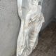 Ancient plaster bas-relief of Nike fastening her sandal.