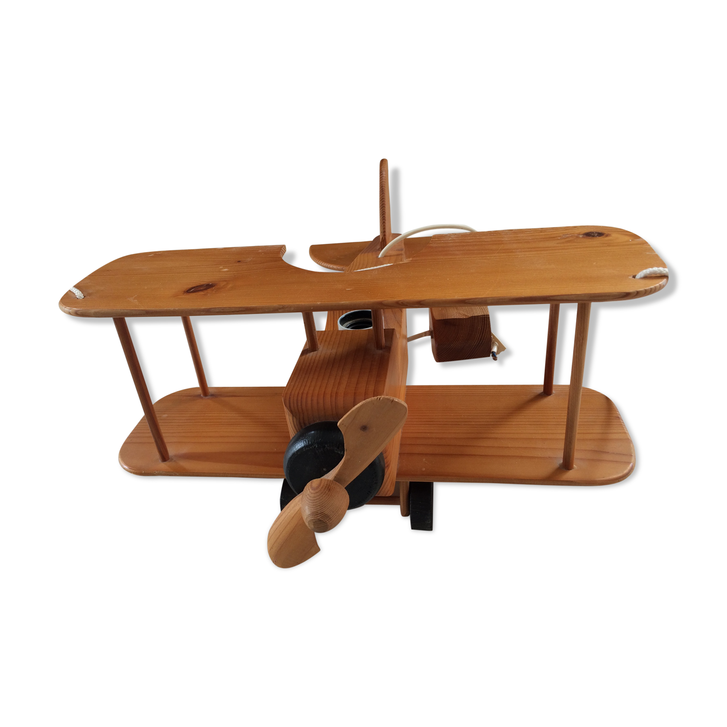 Light wood hanging in the shape of an airplane. Electric.Year 70.