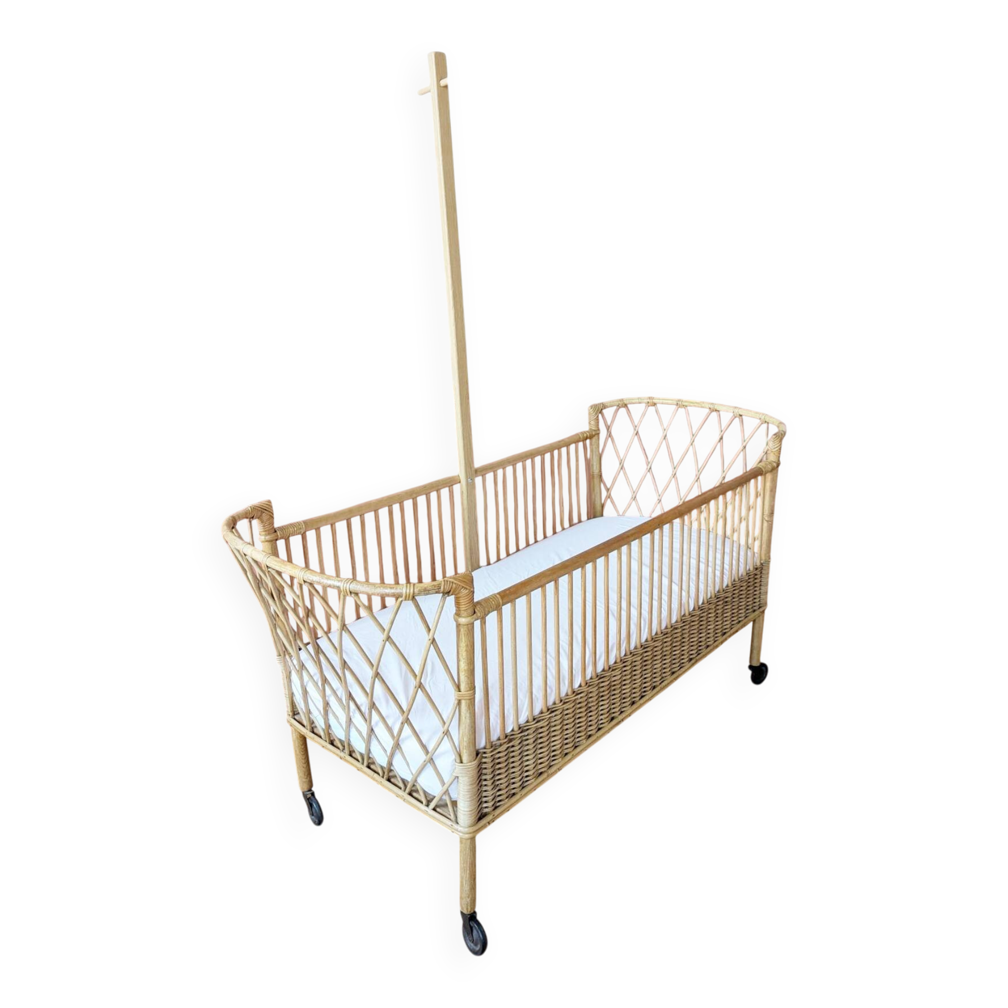 Newly refurbished rattan baby crib, with an oak arrow for a mobile.