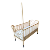 Newly refurbished rattan baby crib, with an oak arrow for a mobile.