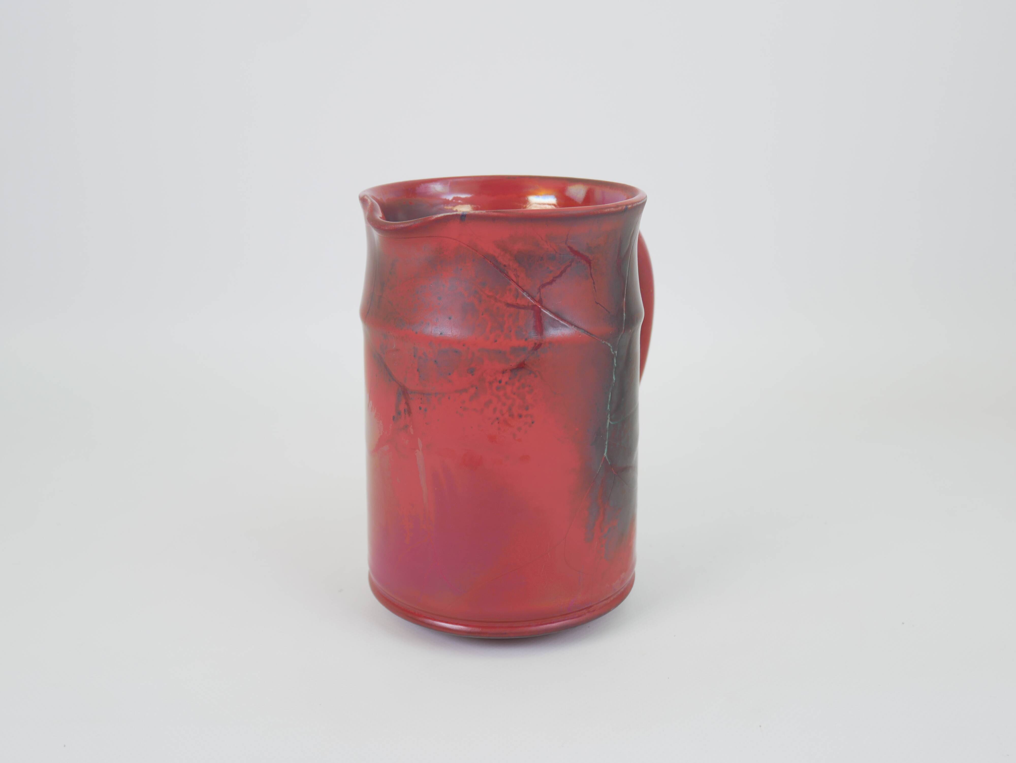 Red glazed ceramic jug with relief