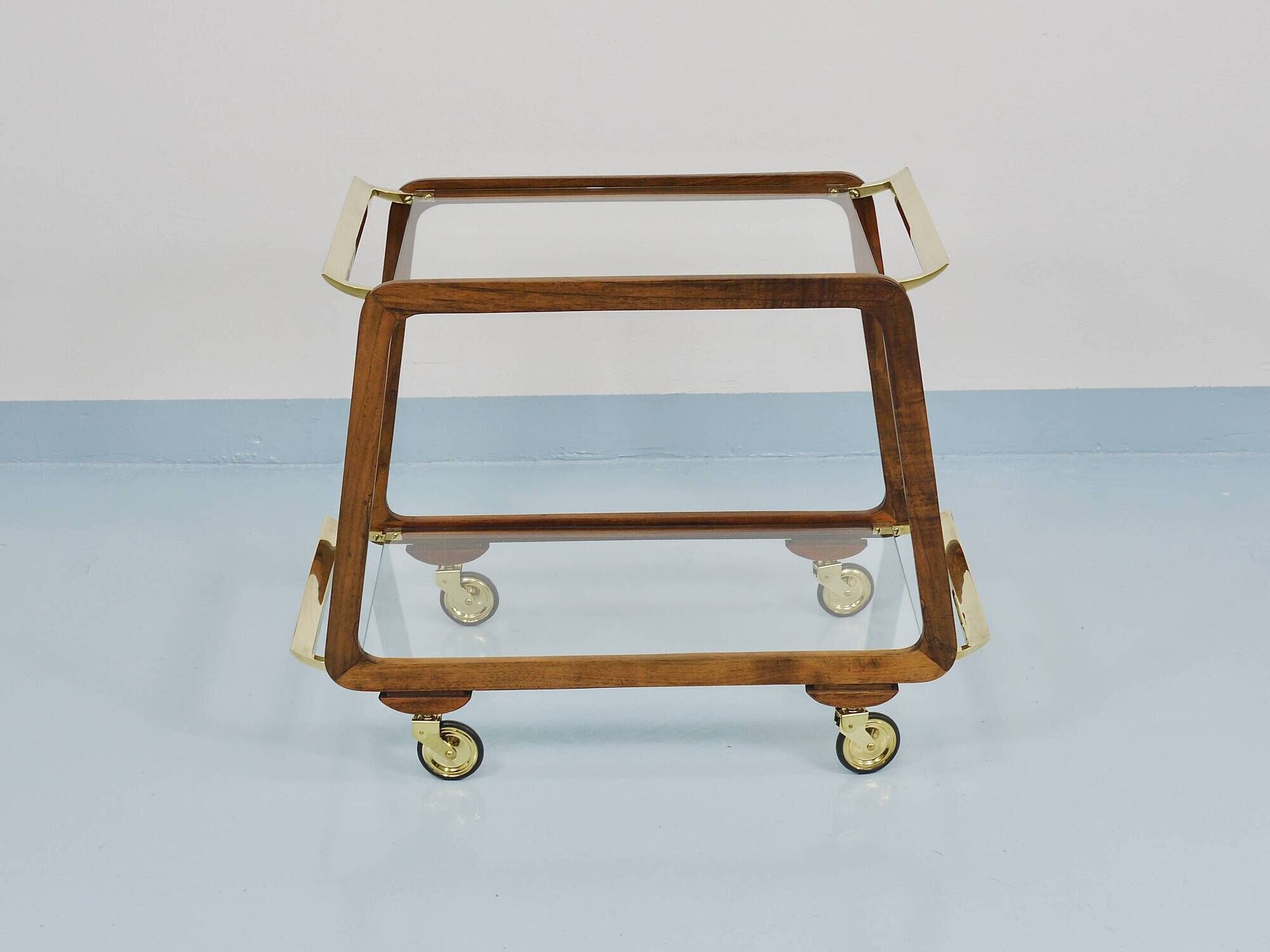 May include: A mid-century modern bar cart with a dark wood frame and two c