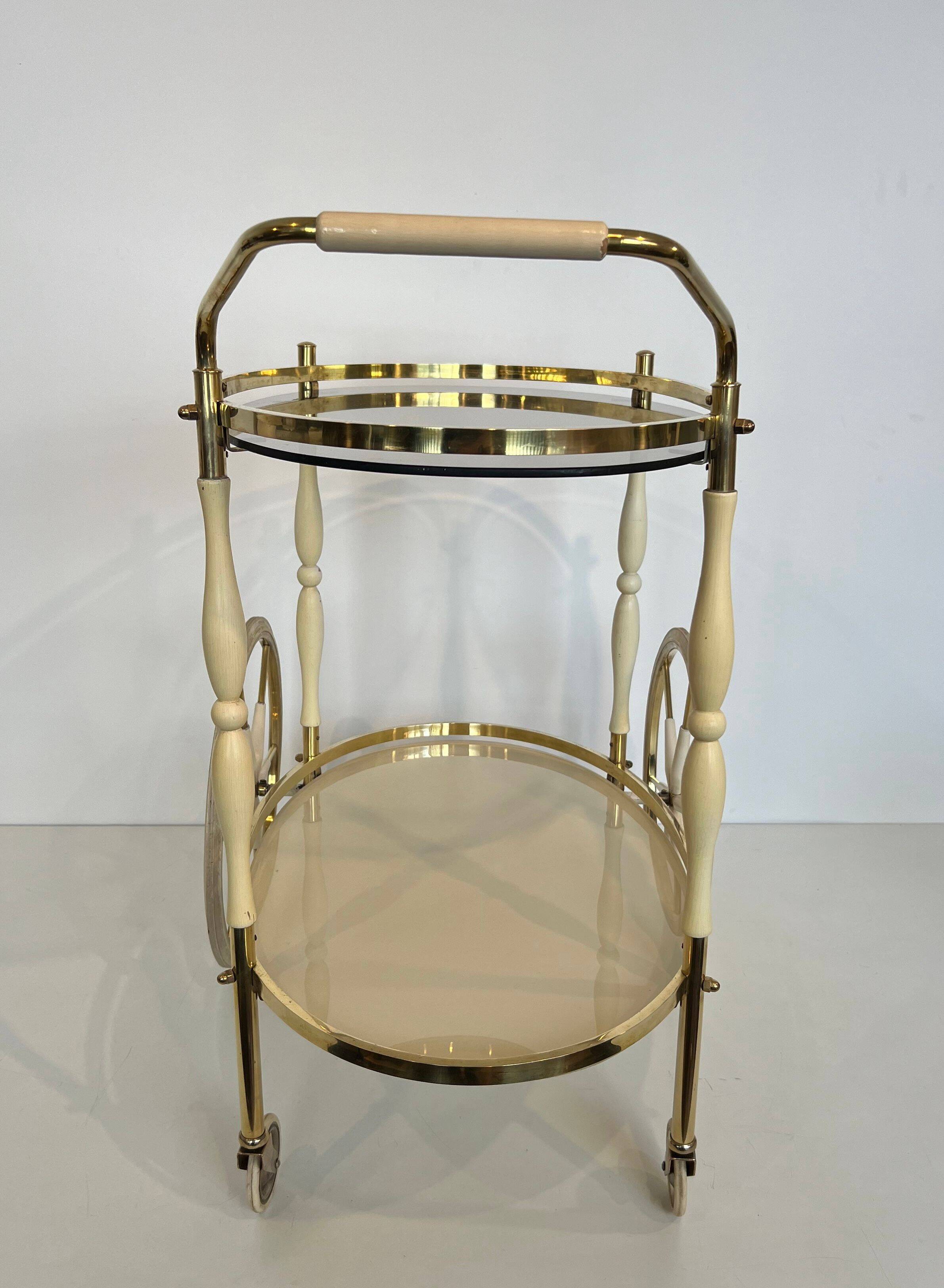 Italian oval rolling table in brass and lacquered wood.