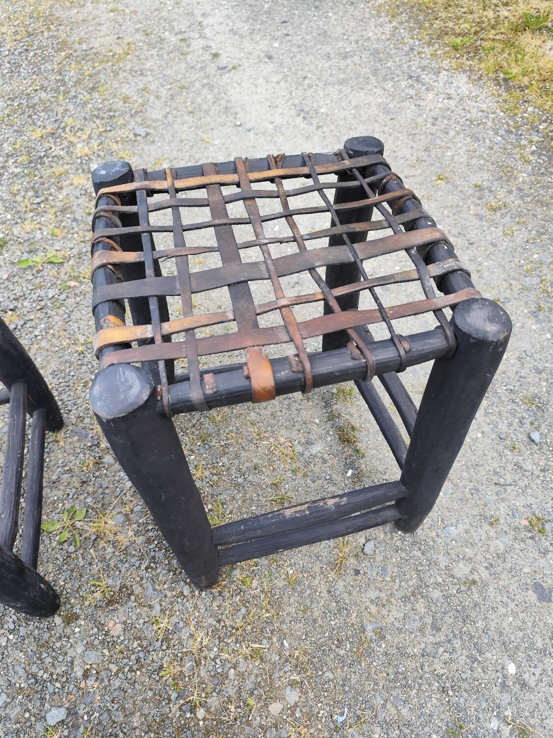 5 blackened wooden stools with woven leather seats by Nina Kaufmann