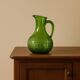 Antique vintage pitcher in green molded glass with floral relief - retro decoration