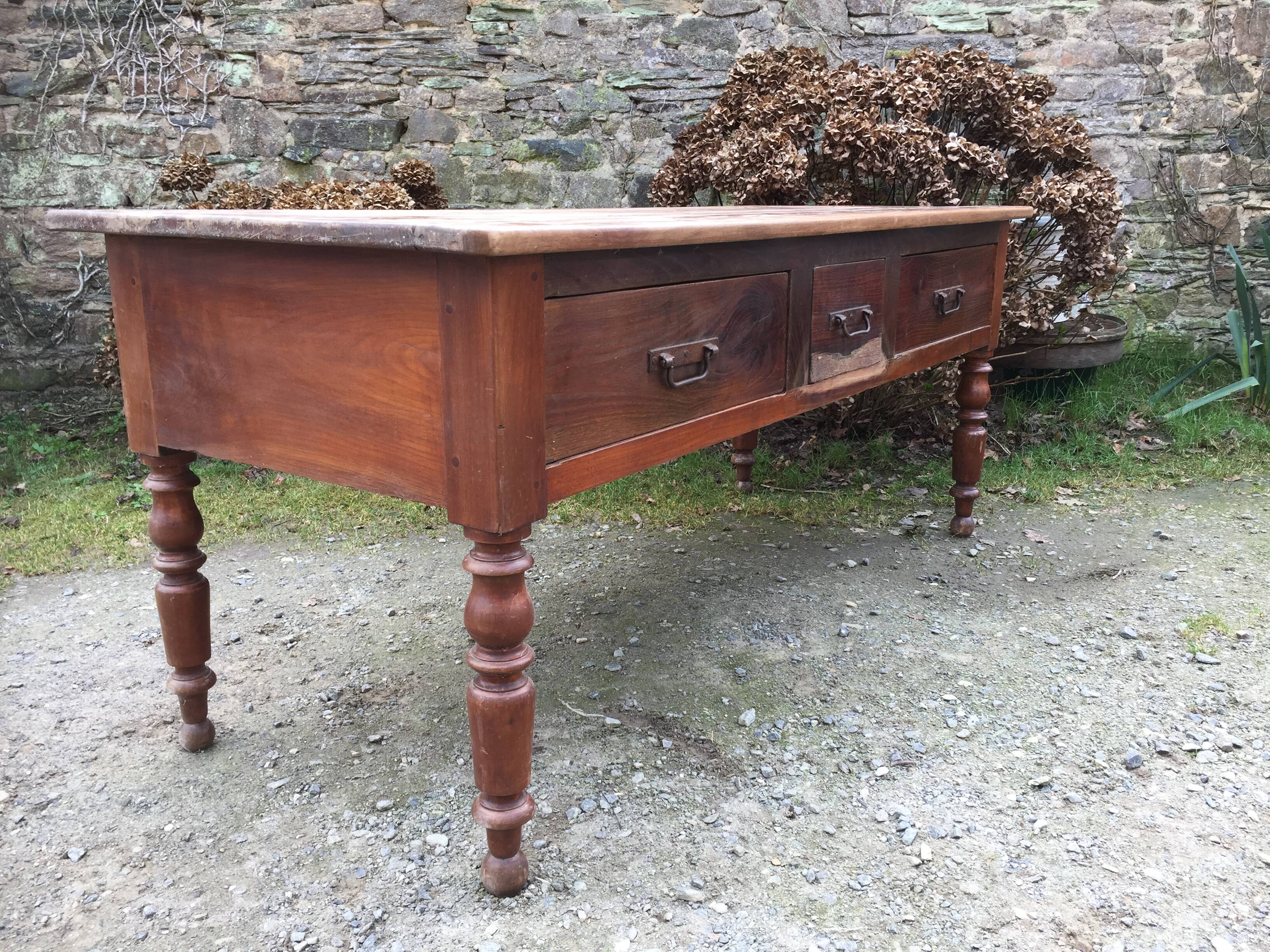 Old farmhouse table with cherry and chestnut panels with 3 drawers.