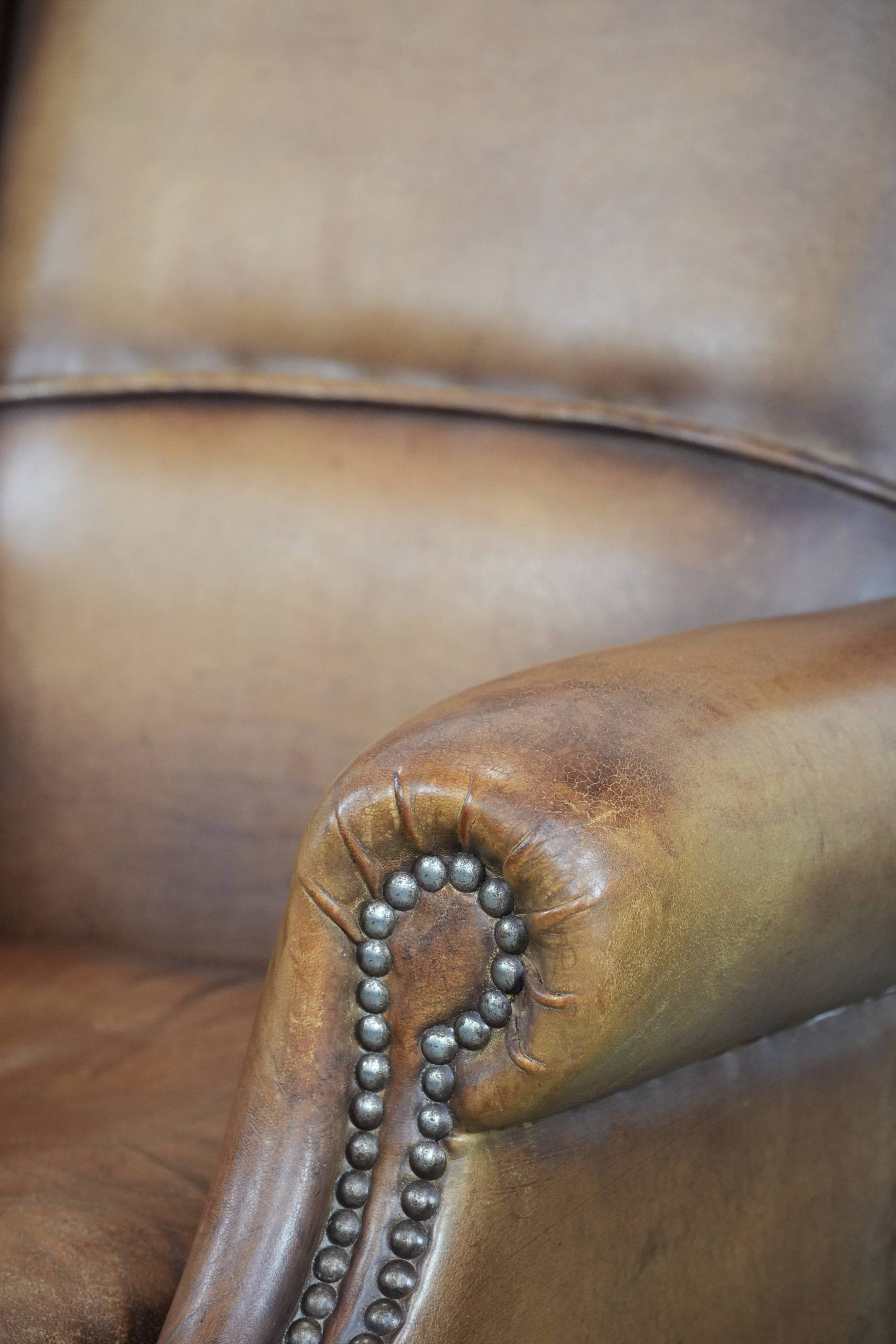 Fauteuil à oreilles en cuir de mouton charmant avec des couleurs chaudes.