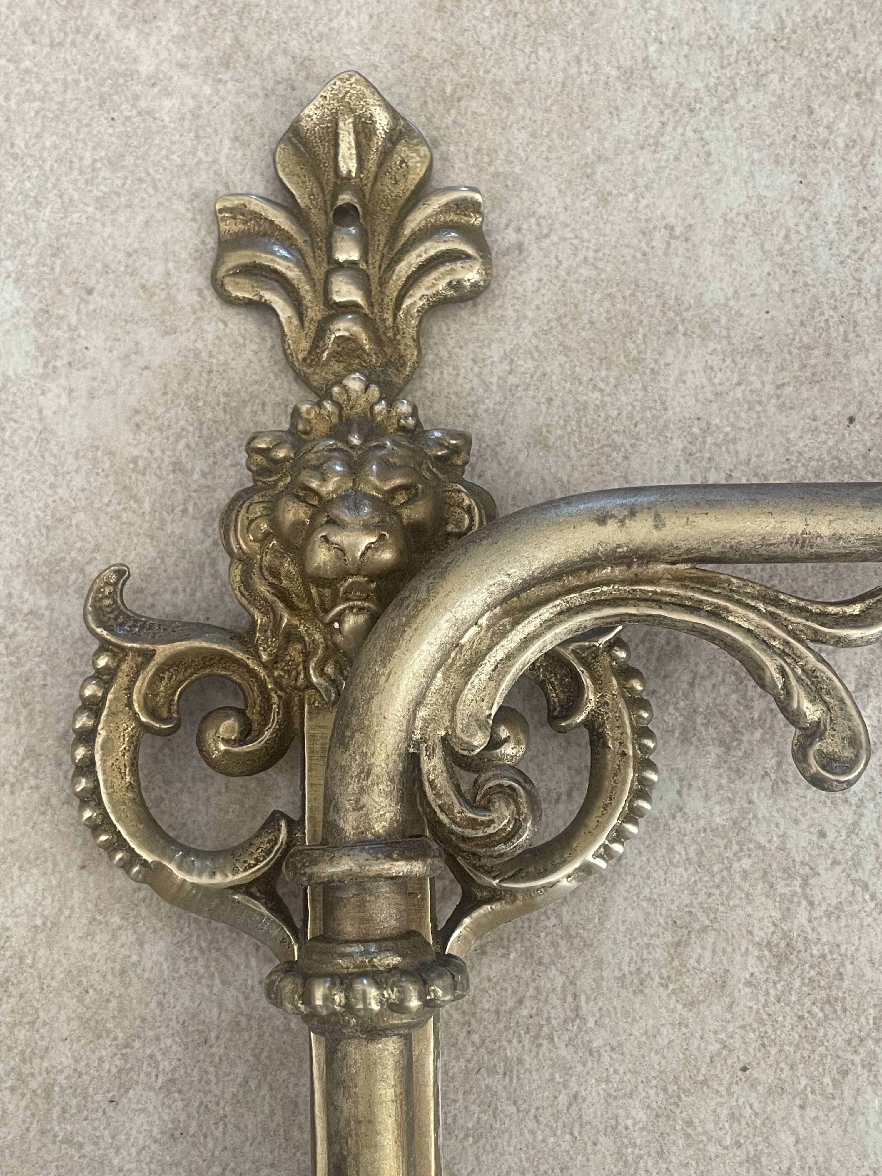 Adjustable wall light in brass and gold metal.