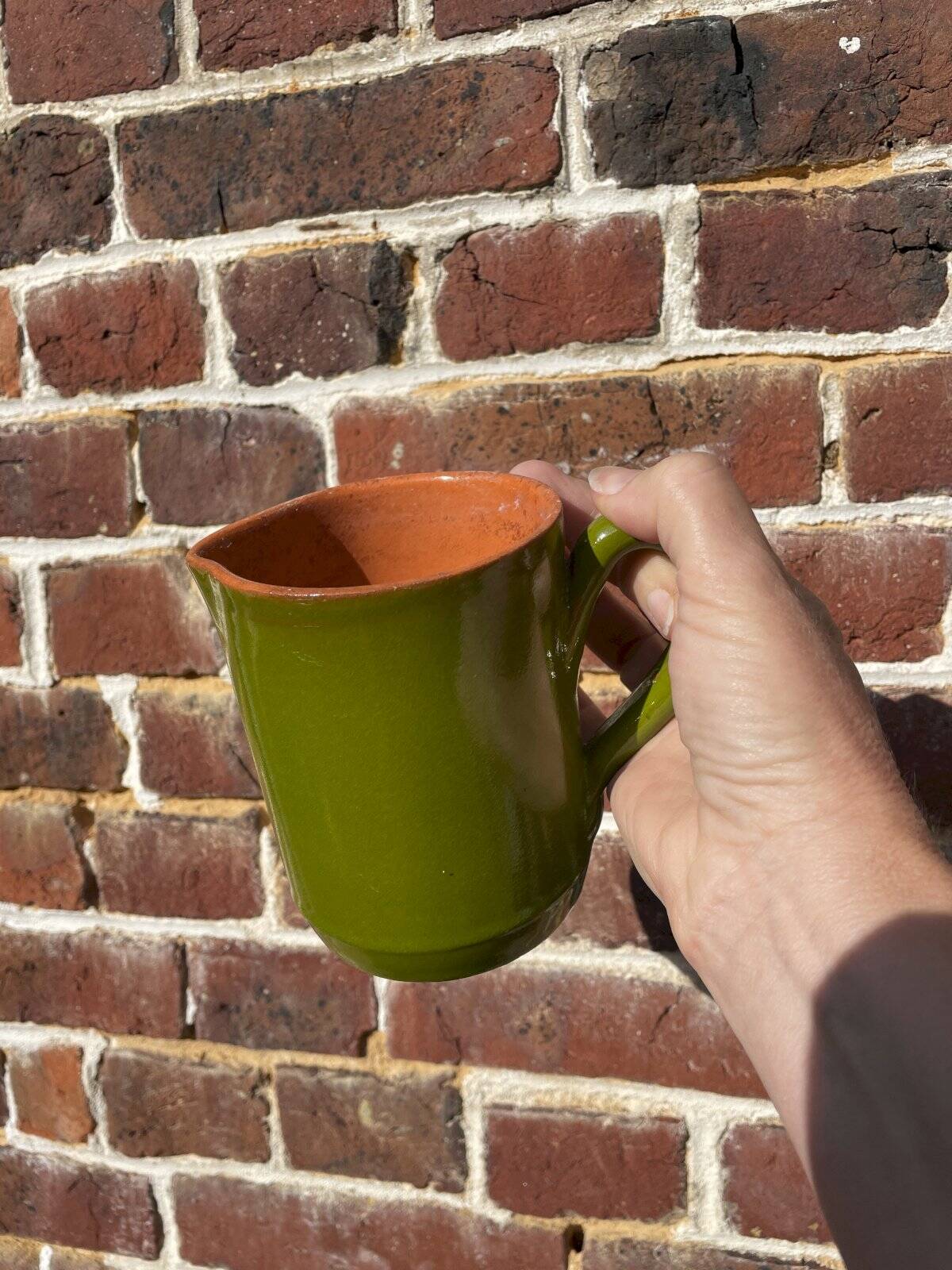 Small two-tone green glazed terracotta jug, height 12 cm.