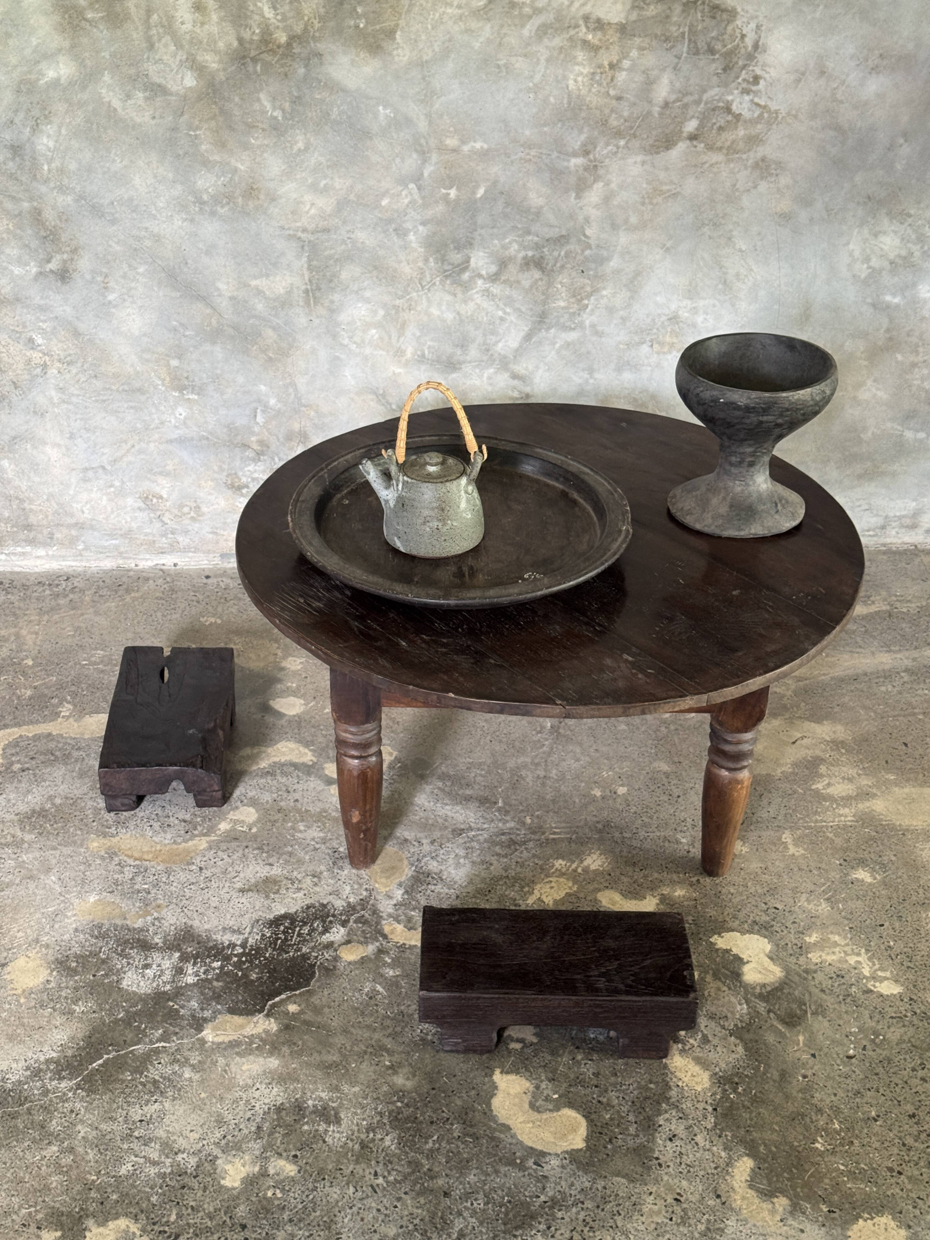 Coffee table, round antique Indonesian teak table with straight legs.