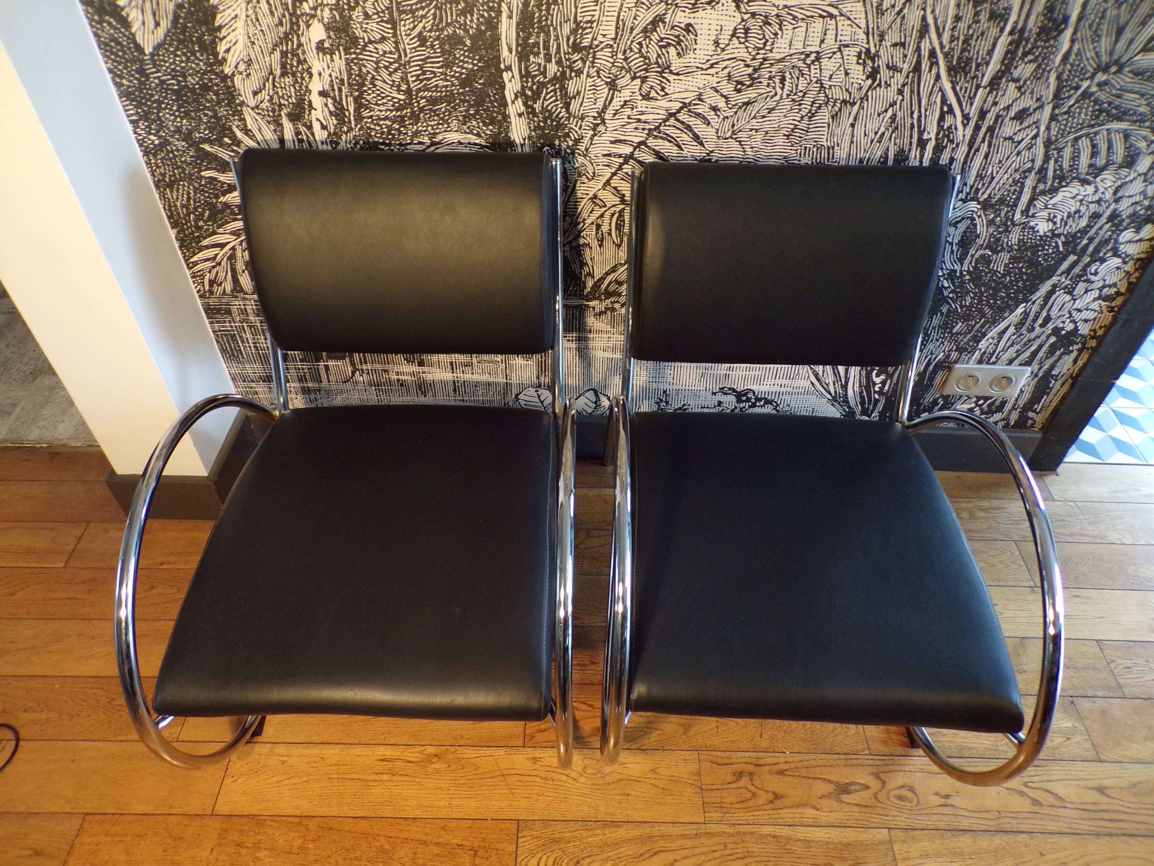 Pair of chrome and faux leather armchairs