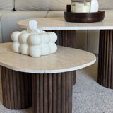 Oval coffee table duo travertine and fluted wooden legs.