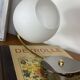 Antique swan neck wall light in brass with a white opaline tulip shade.