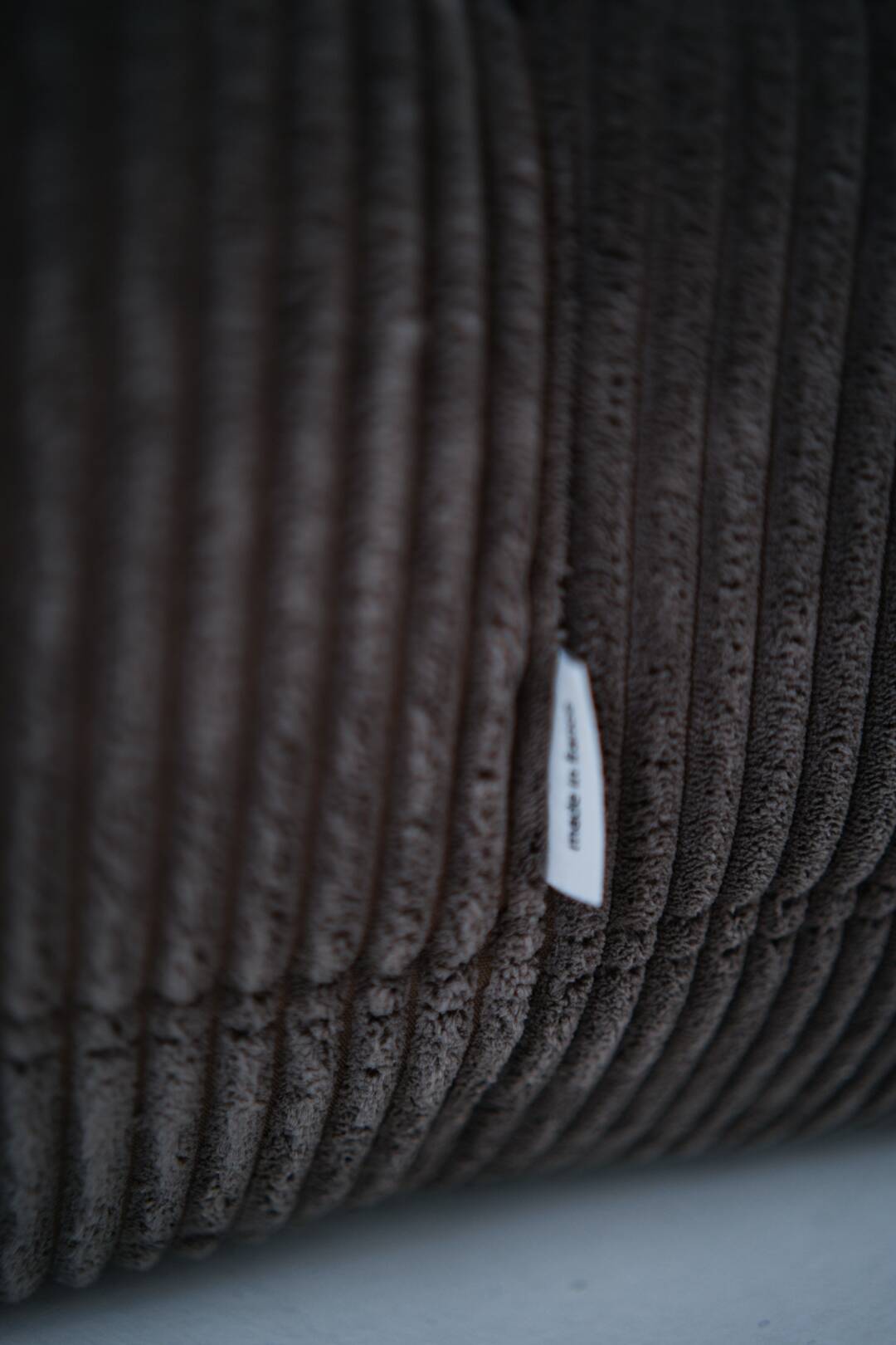 Ensemble de chaise et pouf Togo en velours côtelé marron.