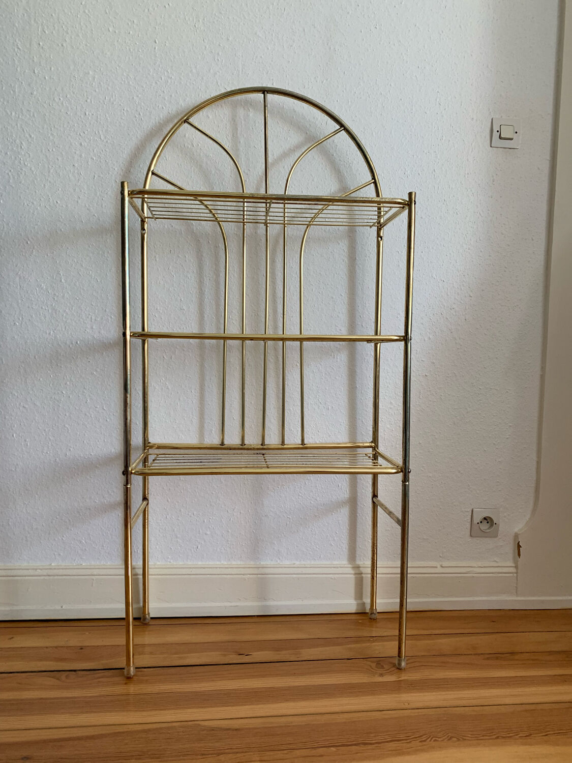 Gilded metal grid shelf in the shape of a vaulted arch