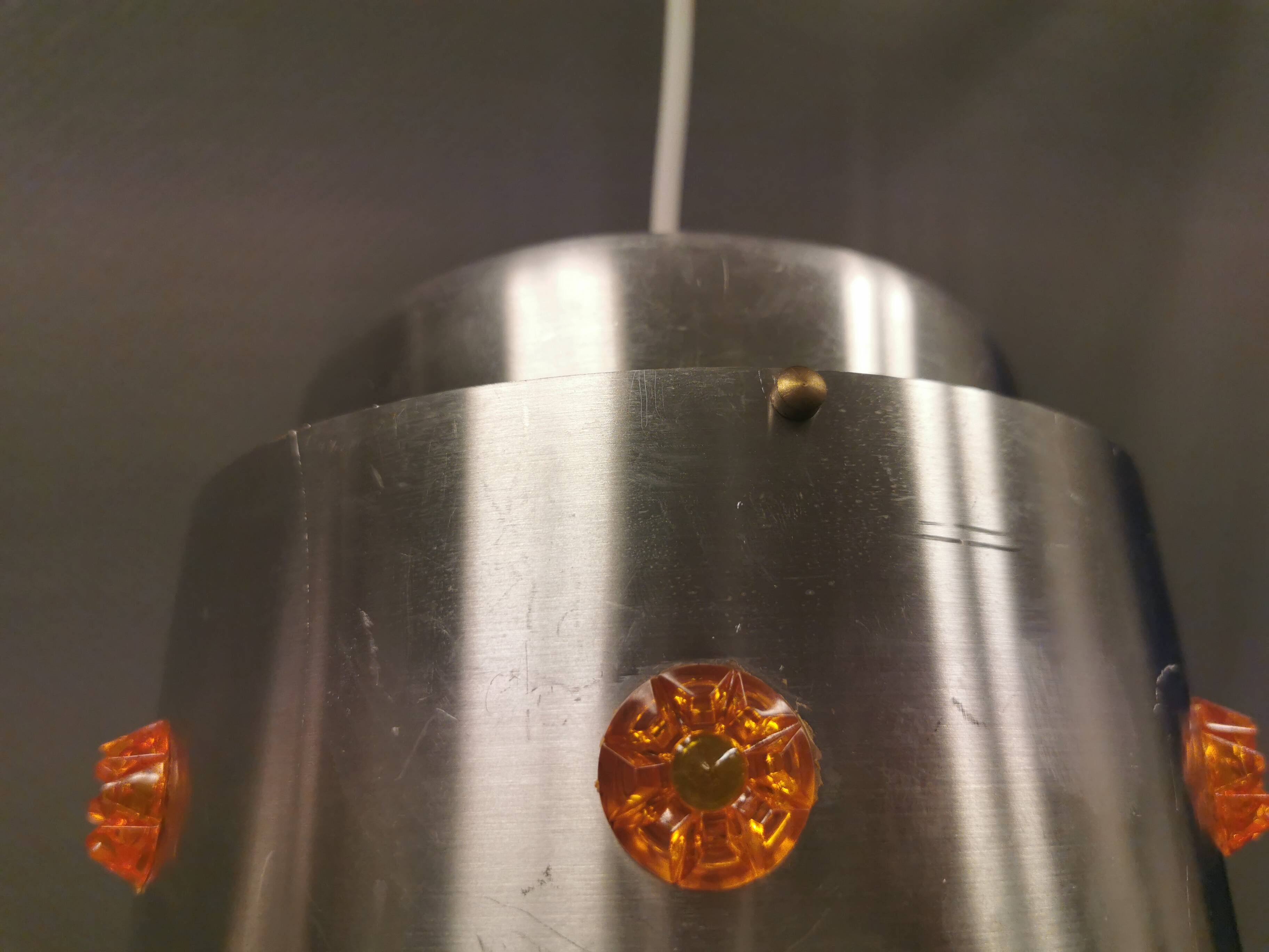 Two Space-Age hanging lamps, in silver-coloured aluminium with orange prisms.