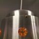 Two Space-Age hanging lamps, in silver-coloured aluminium with orange prisms.