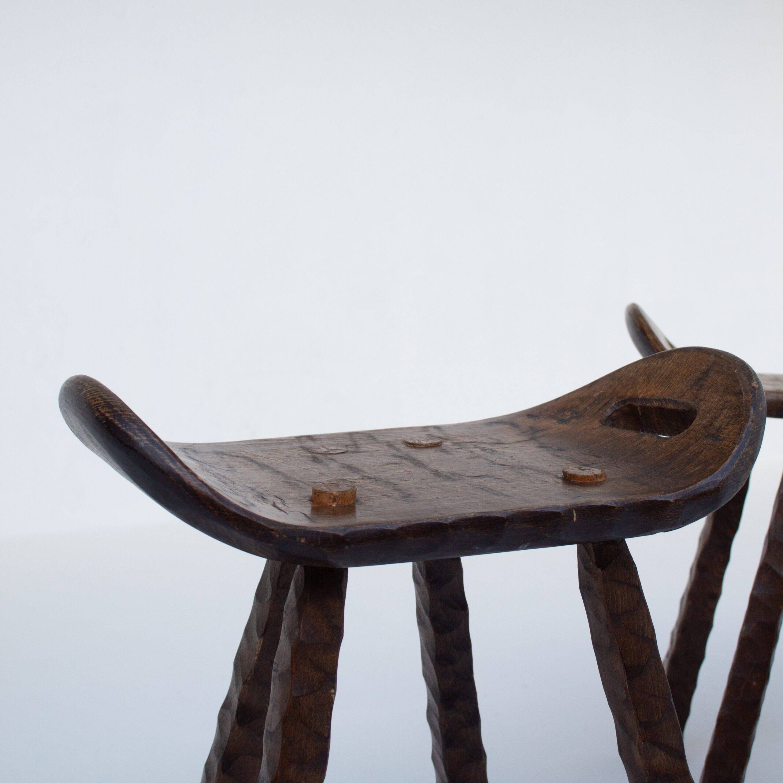 Ensemble de deux tabourets en bois sculptés à la main avec poignées.