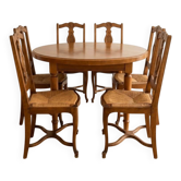 Round table set with 6 wooden chairs with straw seats.