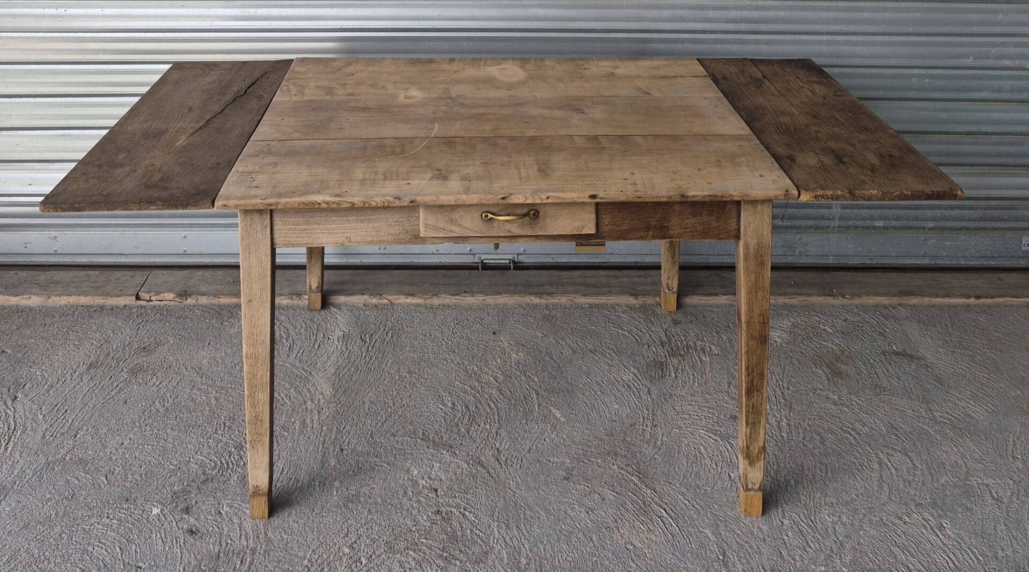 Old farmhouse table with its 2 extensions and raised legs.