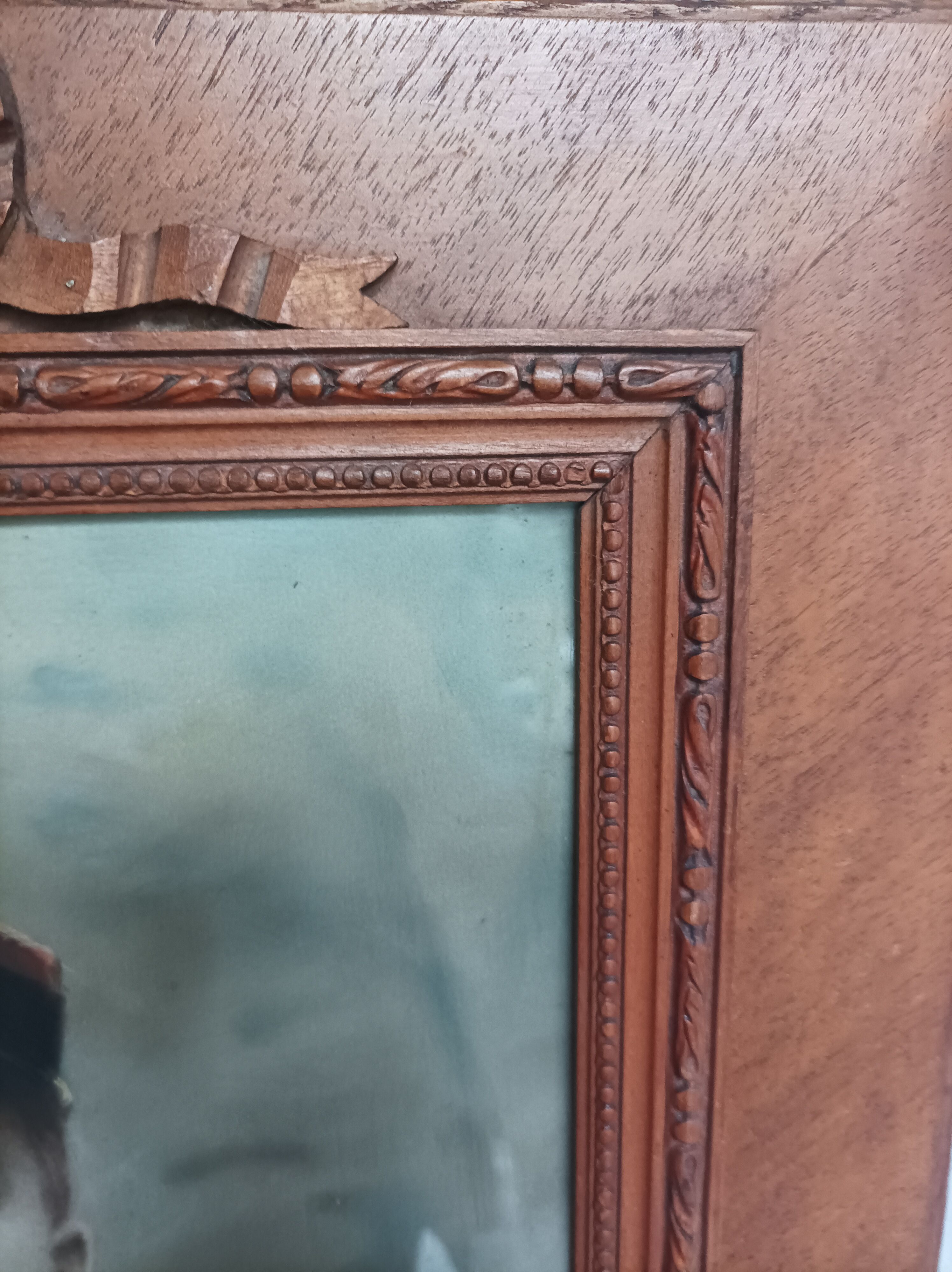 Antique wooden frame with carved portrait knot