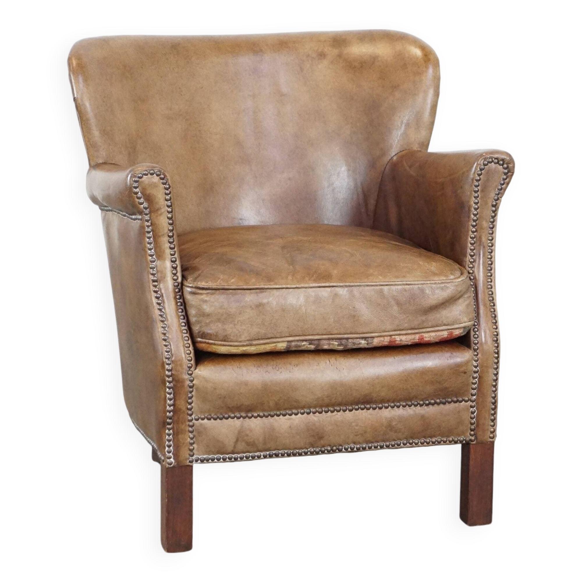 Subtle leather armchair with a reversible kilim seat cushion