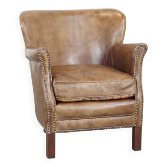 Subtle leather armchair with a reversible kilim seat cushion