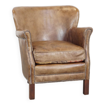 Subtle leather armchair with a reversible kilim seat cushion