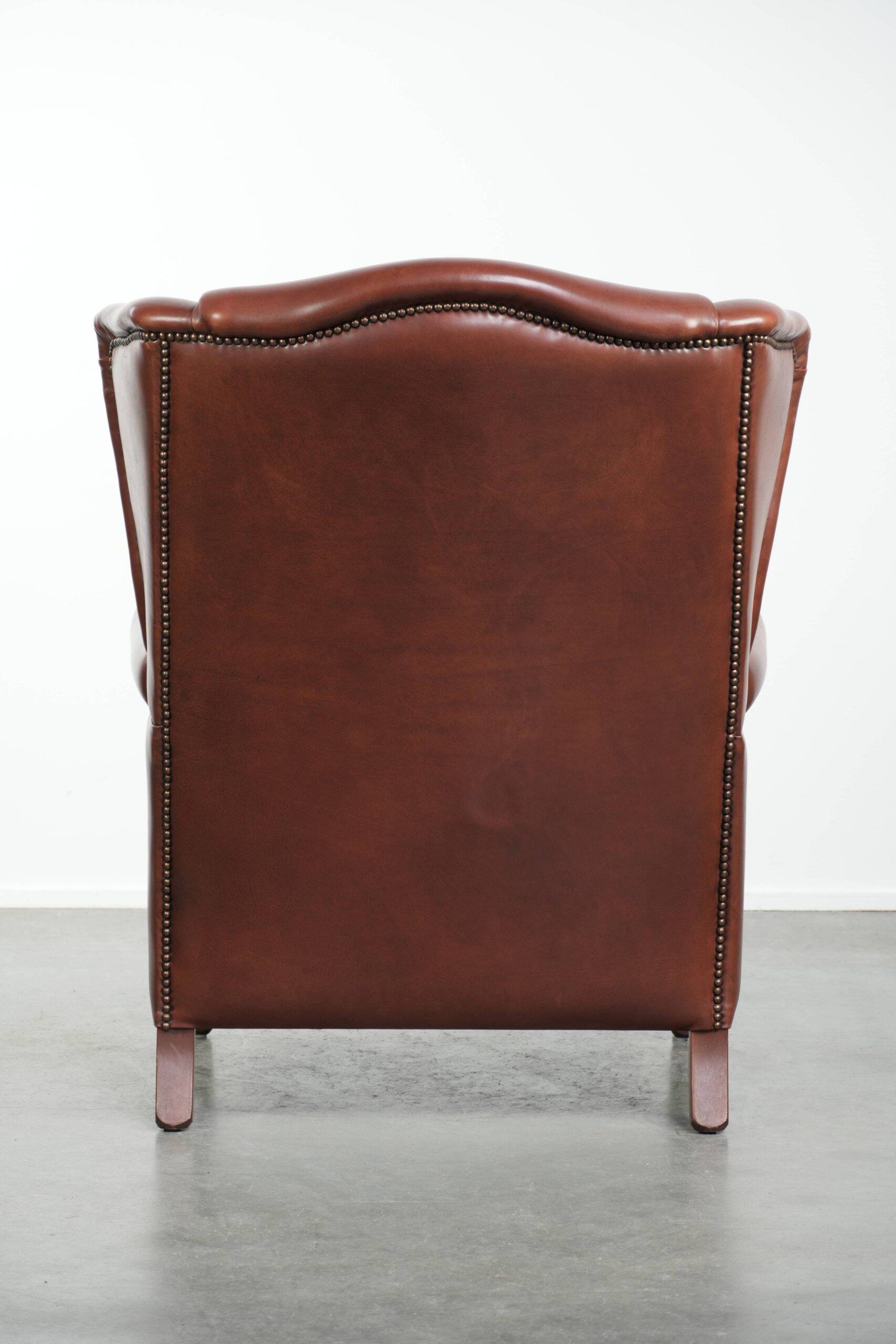 Cognac-coloured cow leather wingback armchair in English style