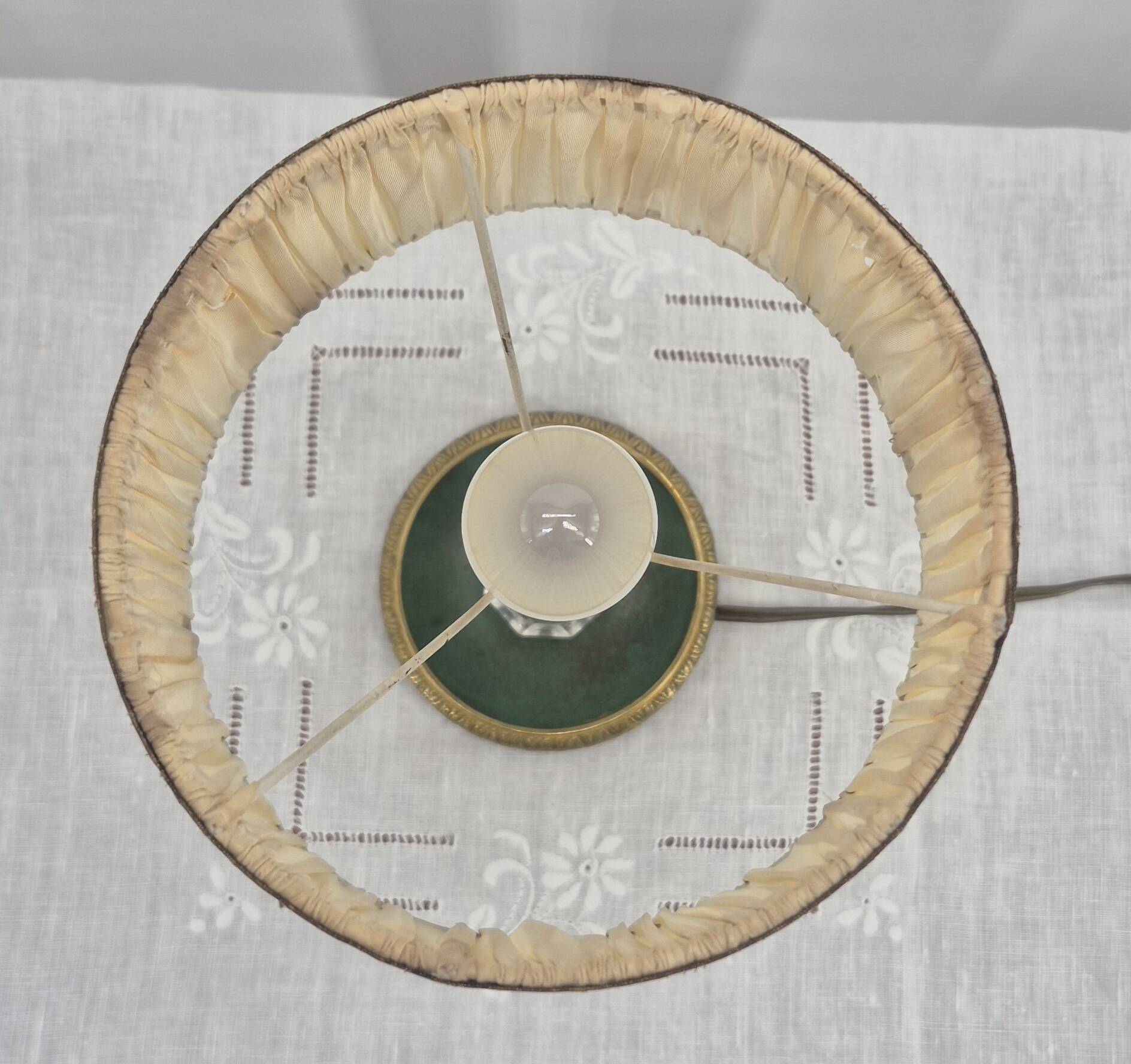 Brass table lamp with green patina and empire-style fabric shade.