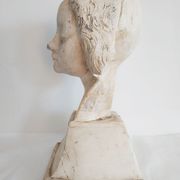 Bust of woman in plaster on pedestal with inscription