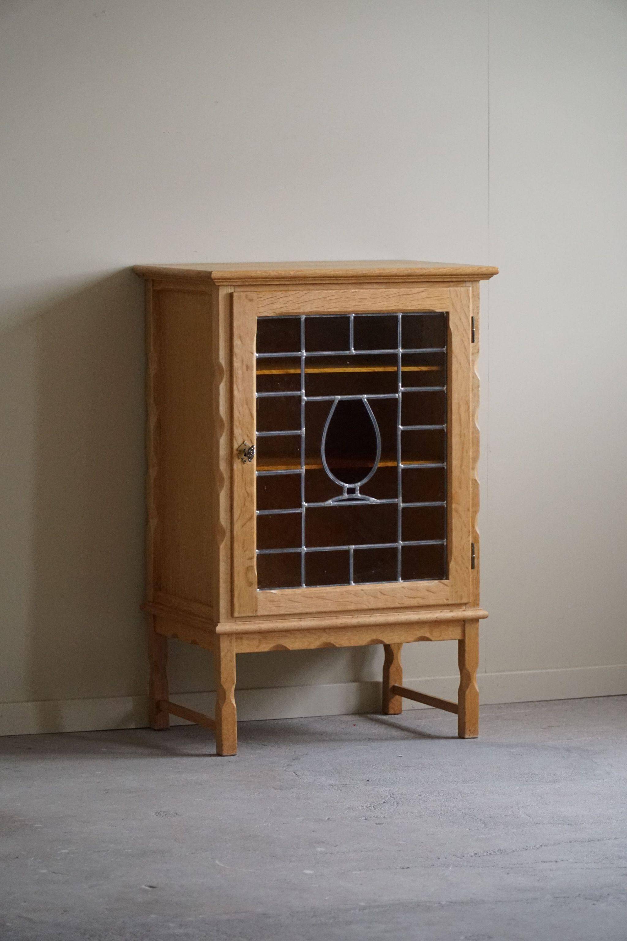 Scandinavian wardrobe in natural oak with a glass front.