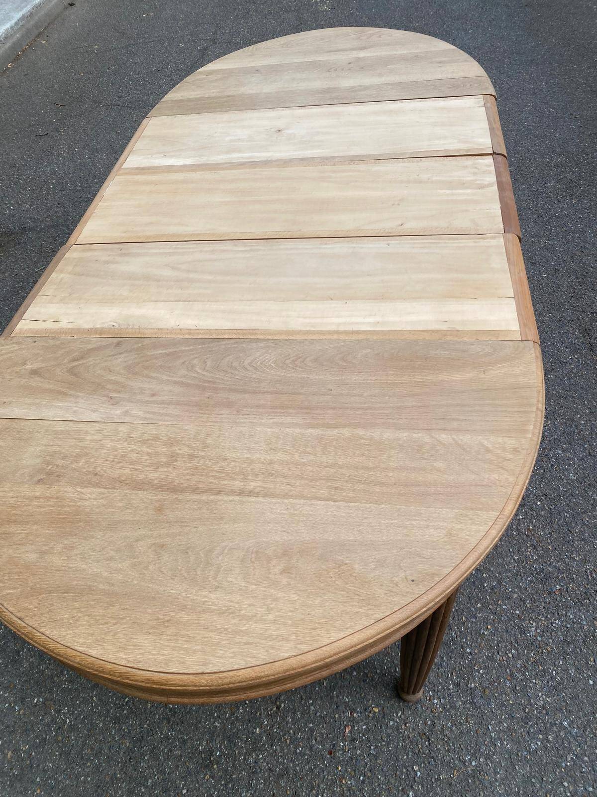 Large stripped solid oak dining table in Louis XVI style with 3 extensions.