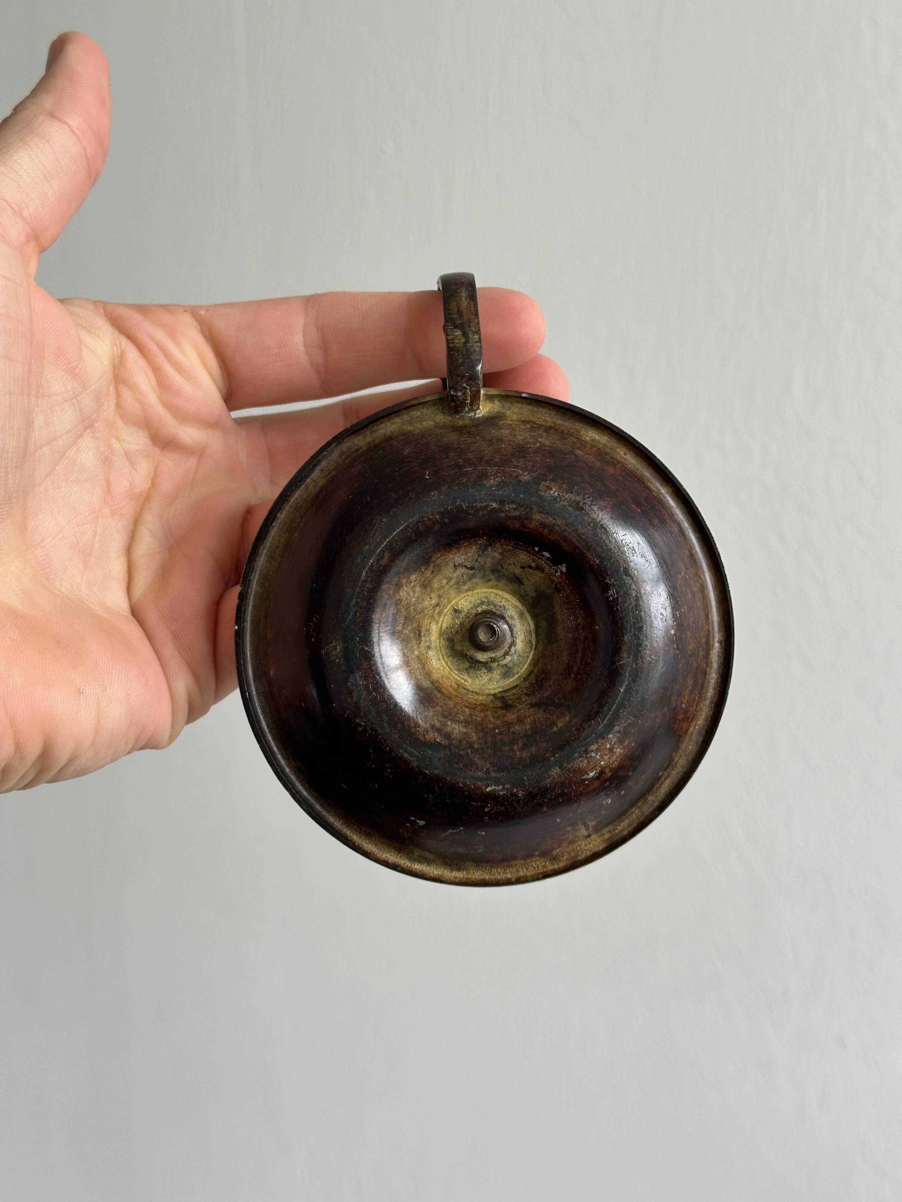Small antique candle holder in patinated metal