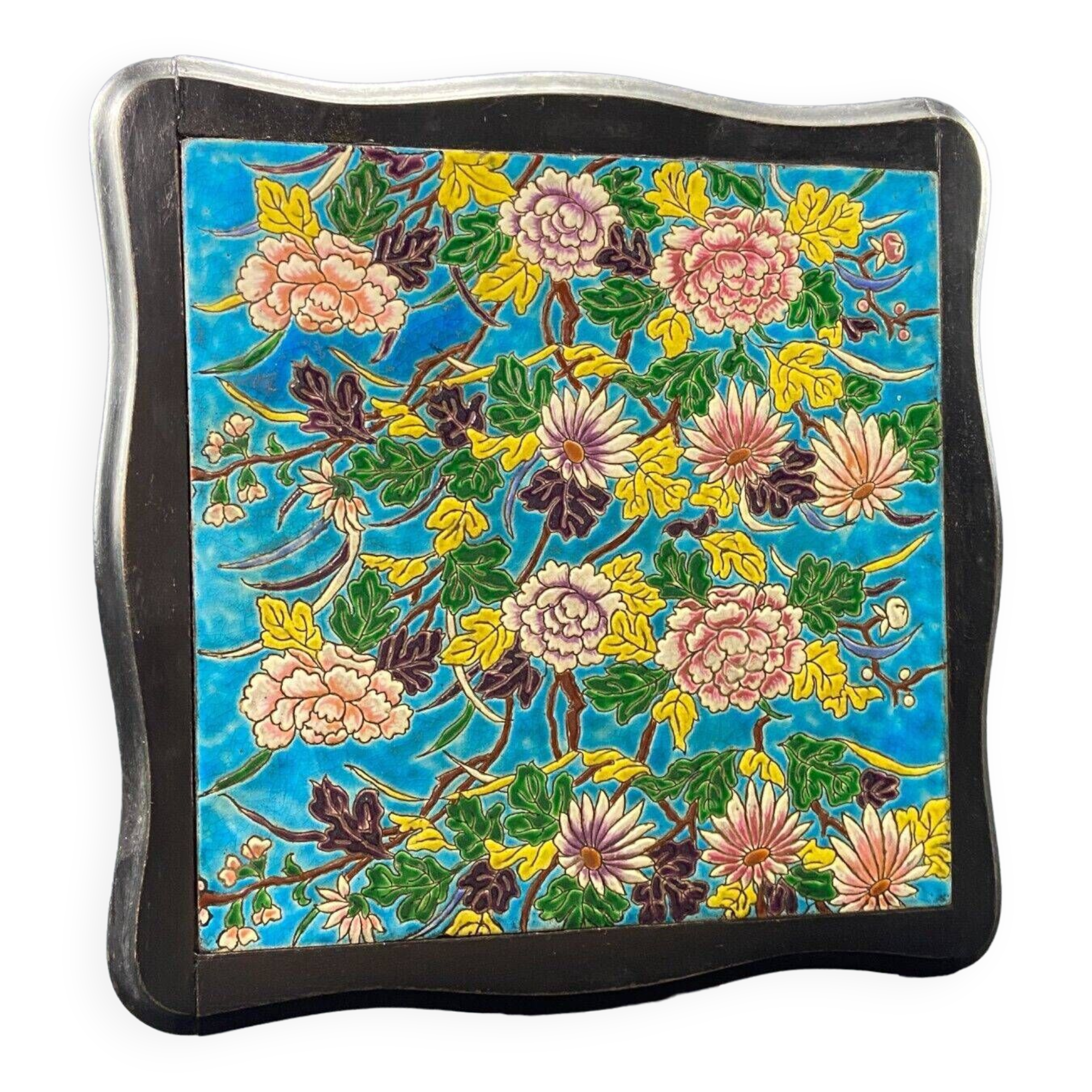 Longwy earthenware trivet on blackened wooden frame