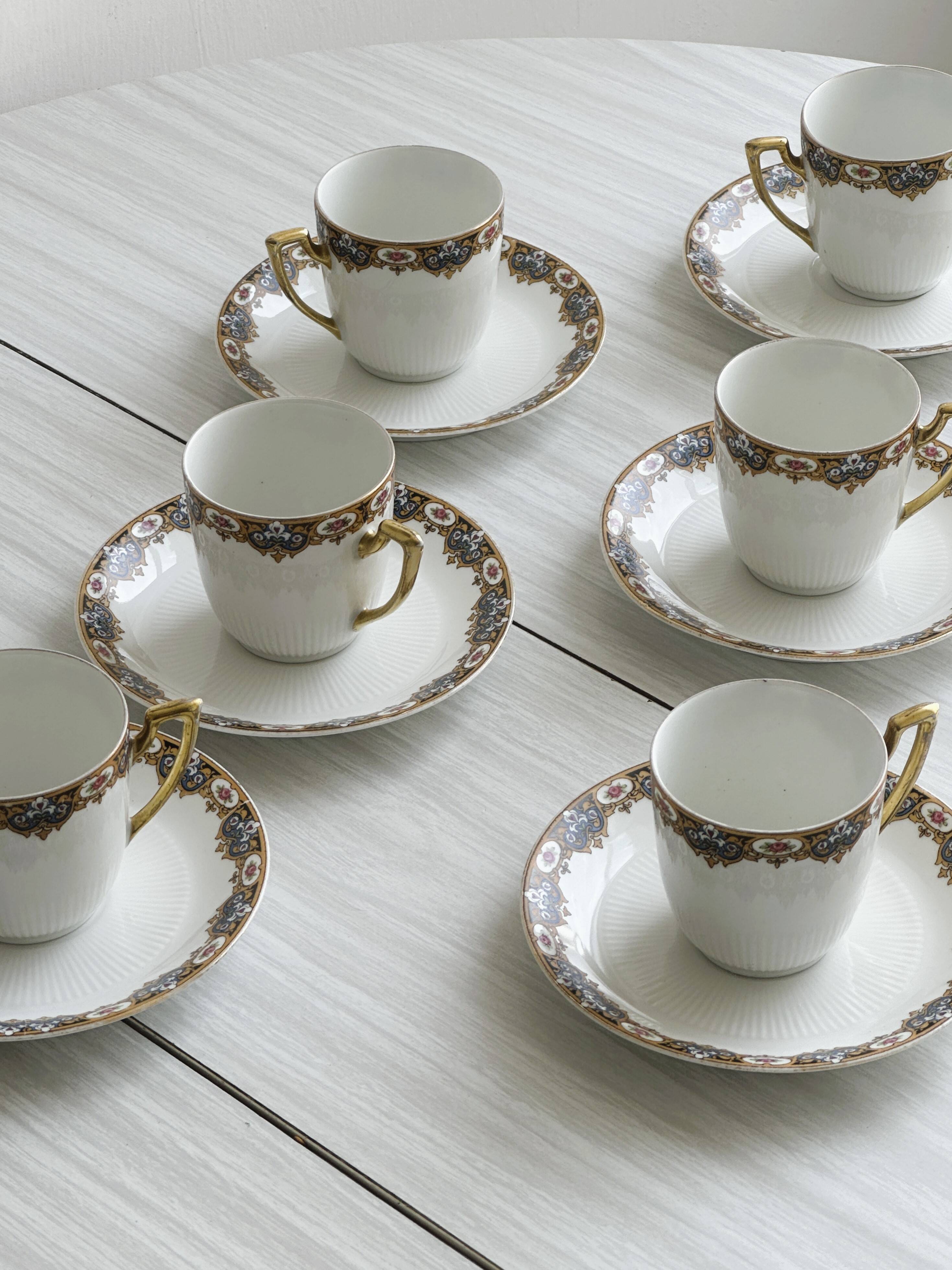 7 Limoges porcelain cups and saucers with gold decoration and floral motif.