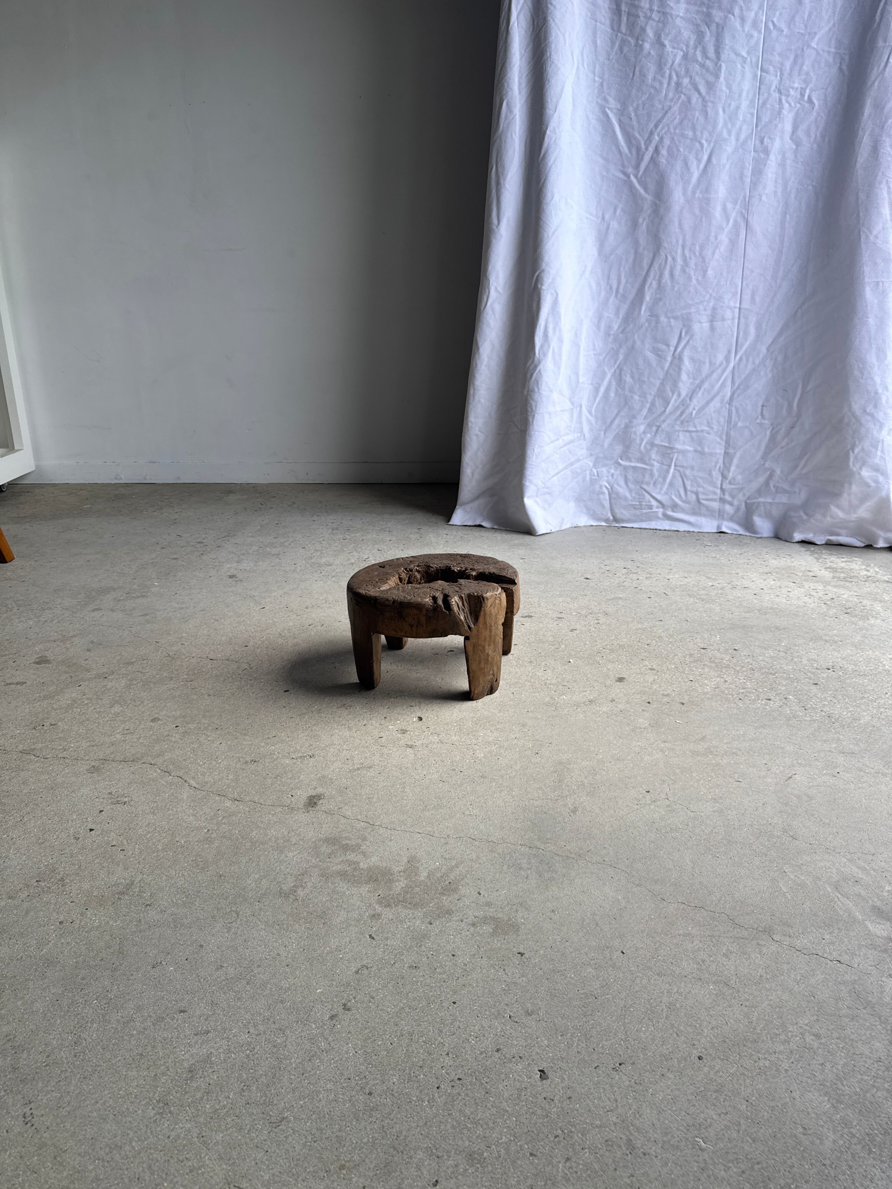 Small low circular four-legged stool in organic old teak with cut-out design H2